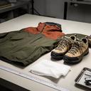 Outdoor-Jacke und Wanderschuhe liegen ordentlich für eine Rückgabeprüfung auf einer Arbeitsfläche
